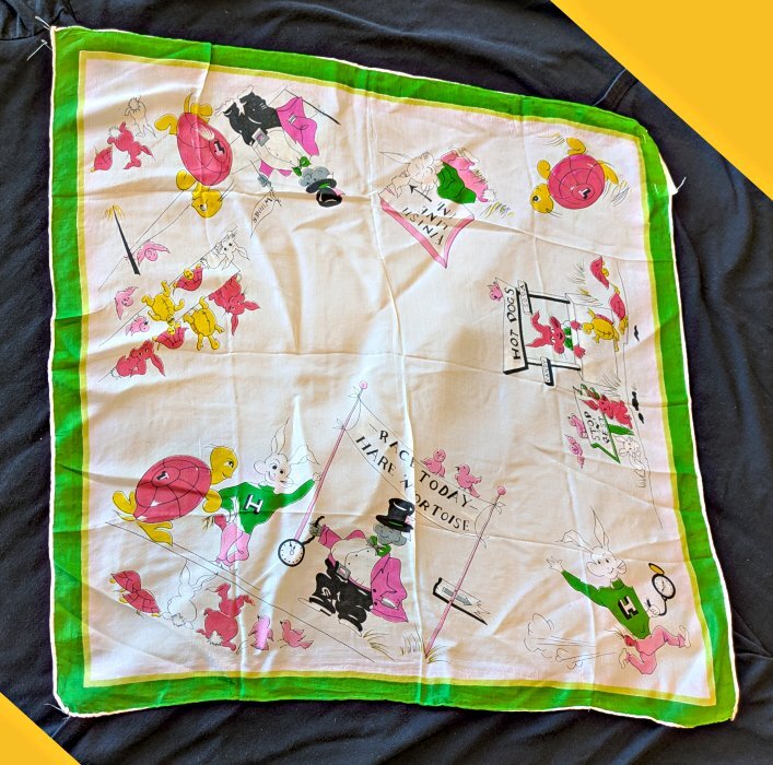 A white scarf with a green border and tortoises and hares on it.