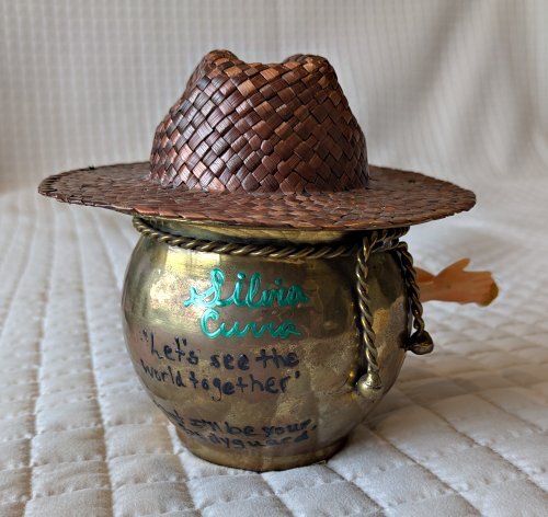 The back of a gold pot with a brown hat.