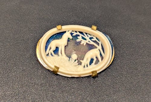 White and blue pin with a wolf and a lamb on it.