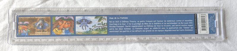 A blue ruler with scenes of a fox and a crow.