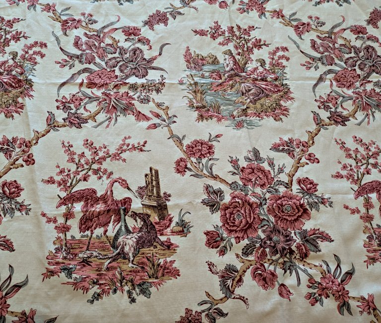 Cloth with pink floral designs and fable scenes.