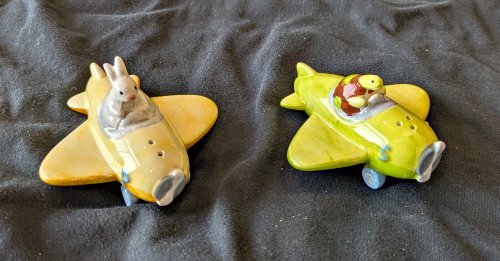 A hare in an orange plane and a tortoise in a green plane.